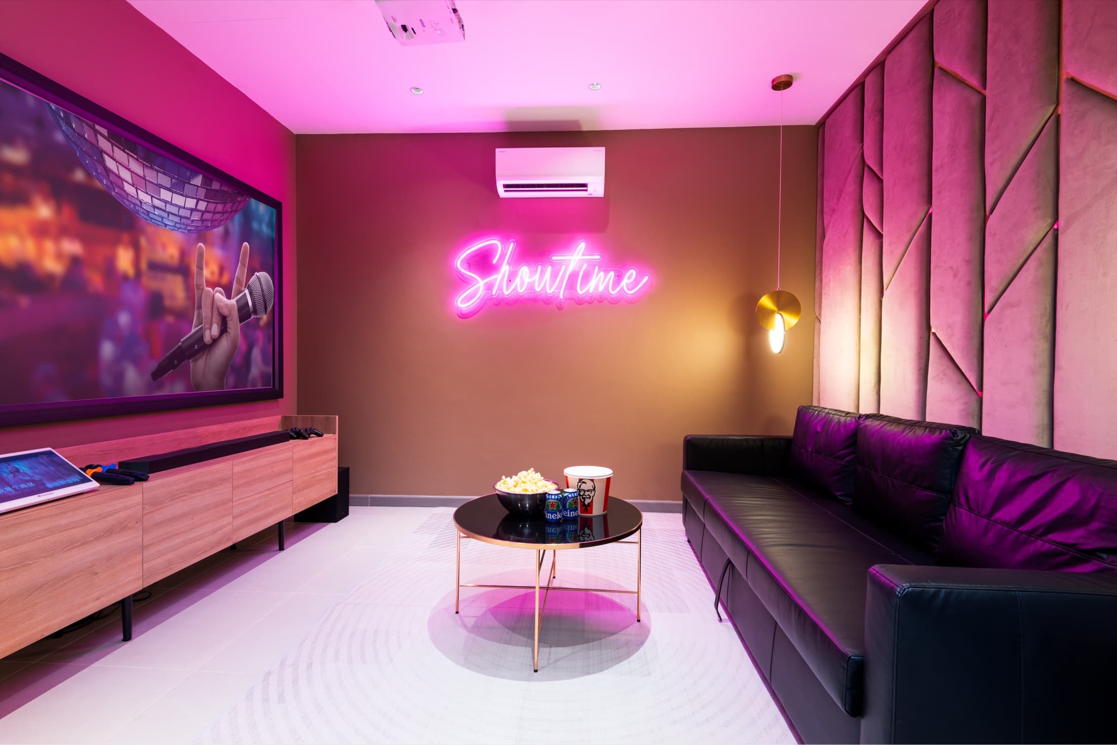 ห้อง KTV ของ Villa Azure ในจอมเทียน พัทยา ป้ายไฟนีออนคำว่า Showtime โซฟาหนังสีดำ โต๊ะกลางพร้อมป๊อปคอร์น และจอโปรเจกเตอร์บนผนัง ห้องที่กลุ่มใช้เคาท์ดาวน์ข้ามปีโดยไม่รบกวนเพื่อนบ้าน